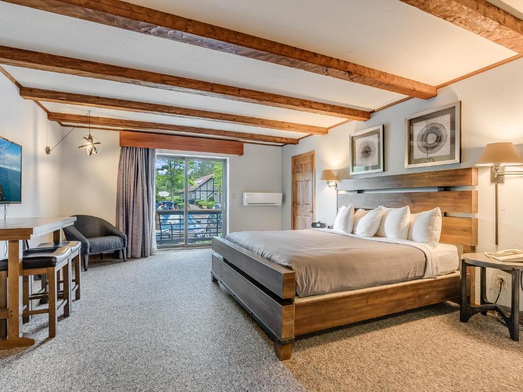Un dormitorio con una cama, un escritorio y una mesa. en Hotel Vienna, en Windham