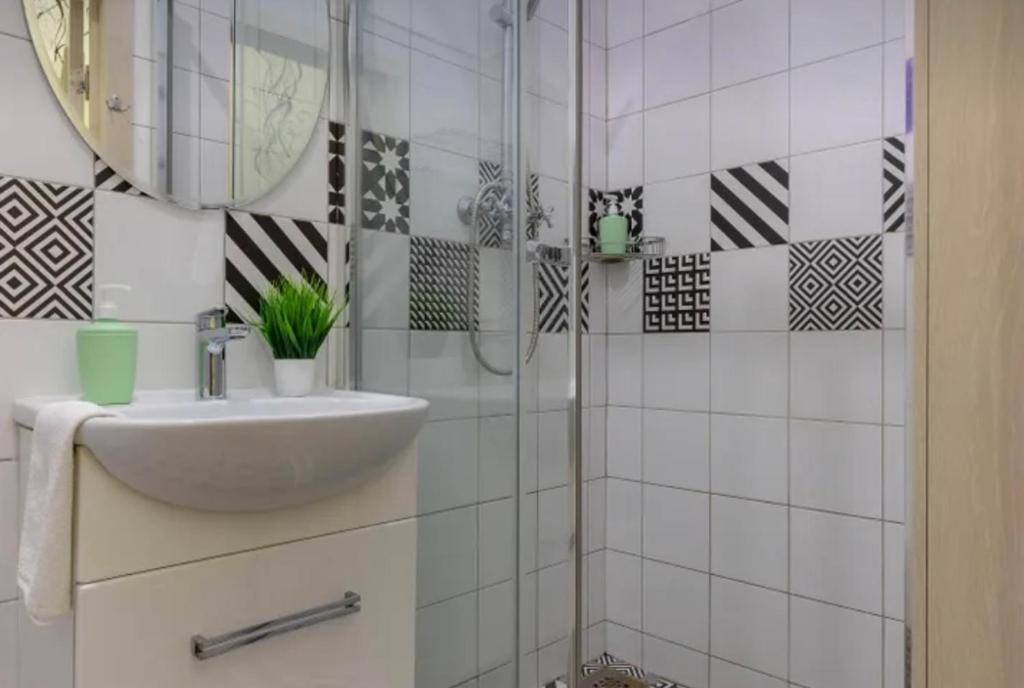 y baño blanco con lavabo y ducha. en VIP apart 655, en Tiflis