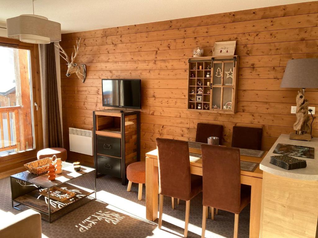 a living room with a dining table and a television at Bel appartement avec piscine, sauna et parkings à Pralognan-la-Vanoise - FR-1-464-217 in Pralognan-la-Vanoise