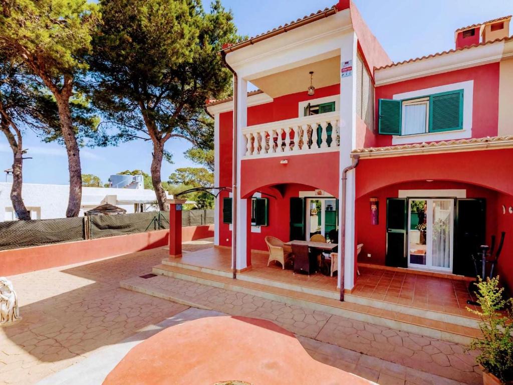 uma casa vermelha com um pátio em Belvilla by OYO Villa Malen s Mallorca em Llucmajor