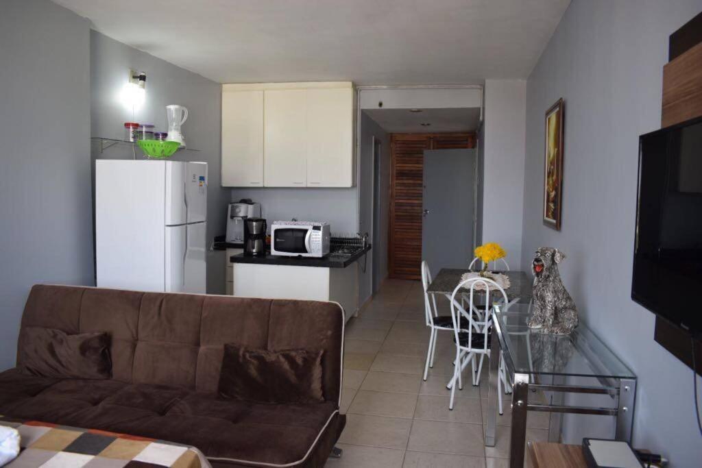 a living room and kitchen with a couch and a table at Loft centro de Goiânia 2108 in Goiânia