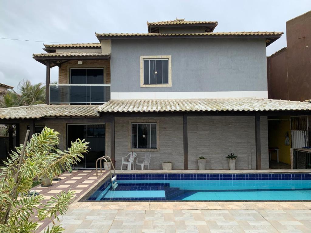 a house with a swimming pool in front of a house at Casa em Unamar Cabo Frio in Cabo Frio