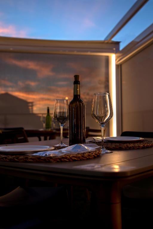 a bottle of wine and two wine glasses on a table at Hotel Boutique Calas de Alicante in Alicante