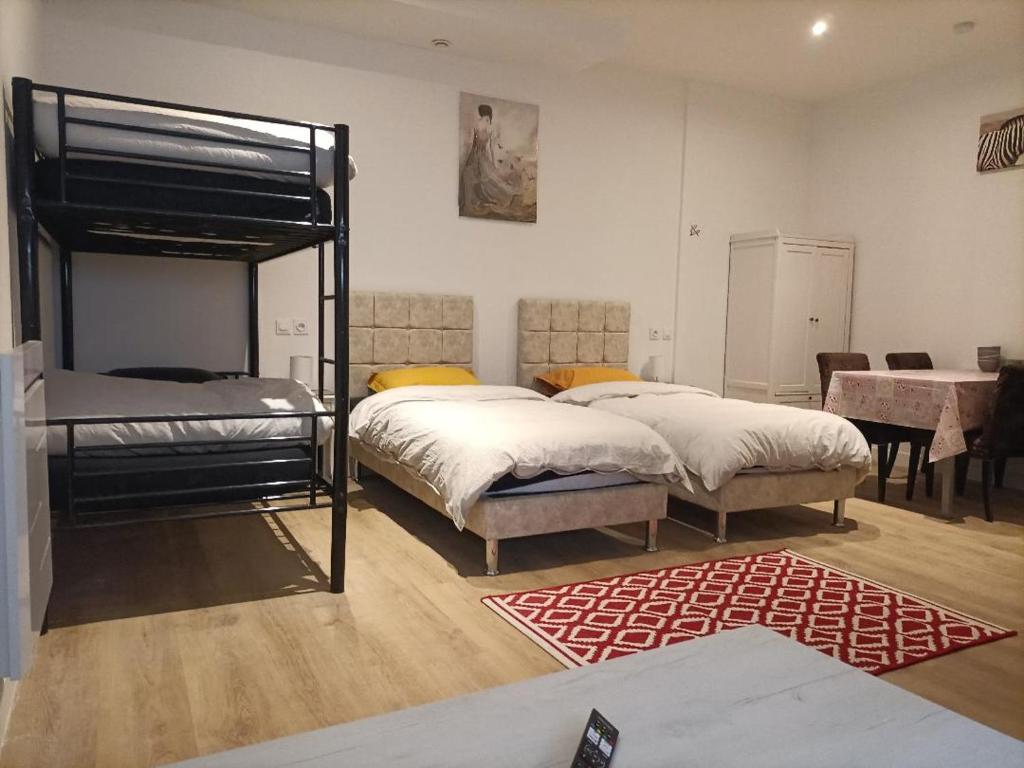 a bedroom with two bunk beds and a rug at À 7 minutes de l'aéroport CDG 1 in Thieux