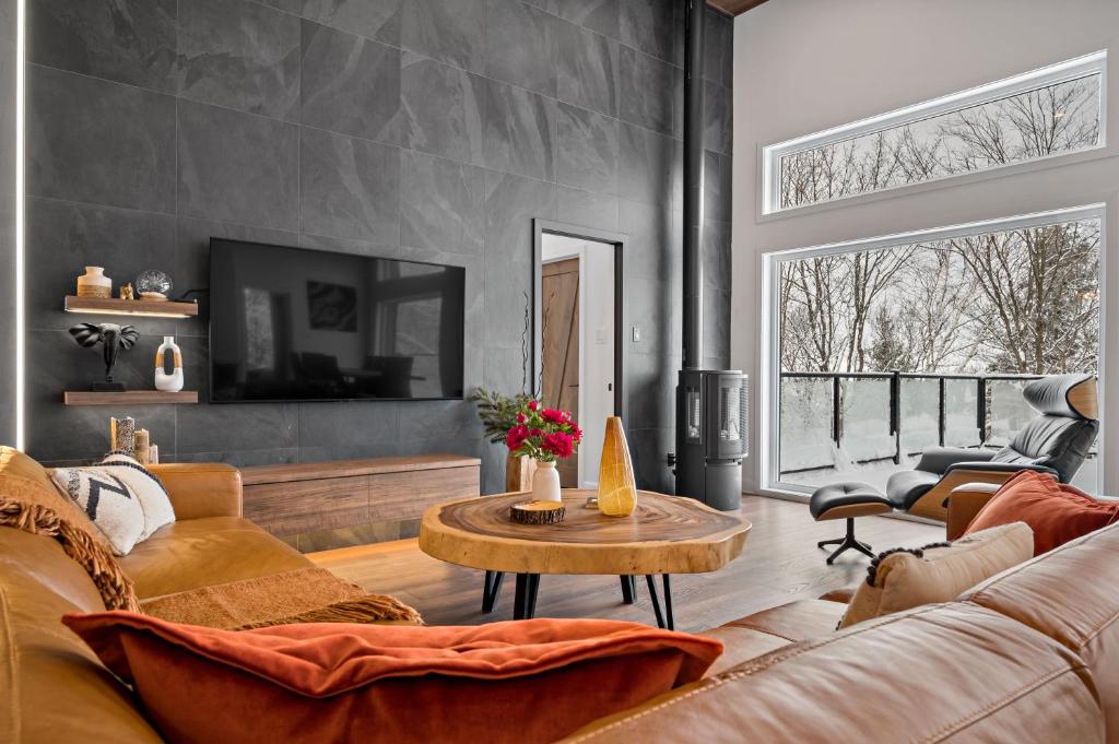 een woonkamer met een bank en een tafel bij Chalet Avala by Tremblant Platinum in La Conception