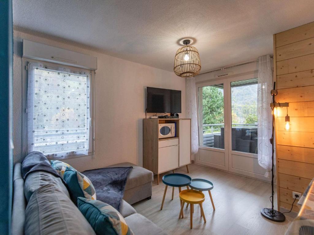 a living room with a couch and a table at Appartement T2 cabine, terrasse, piscine, parking, proche commodités et ski, Luz-Saint-Sauveur - FR-1-402-131 in Luz-Saint-Sauveur