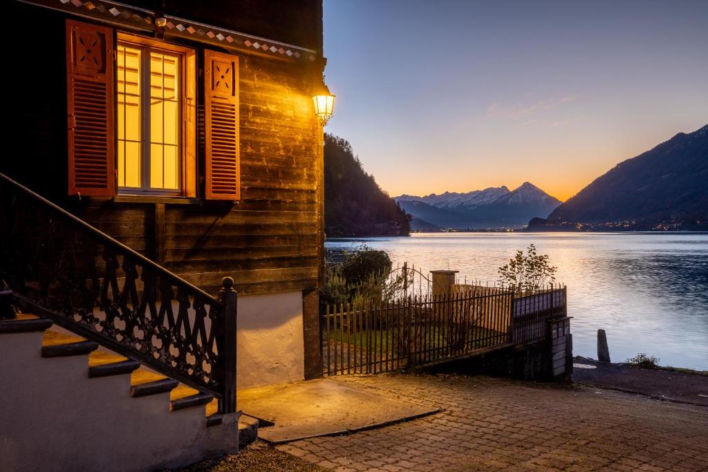 a building with a staircase next to a body of water at Chalet Seehus Iseltwald in Iseltwald