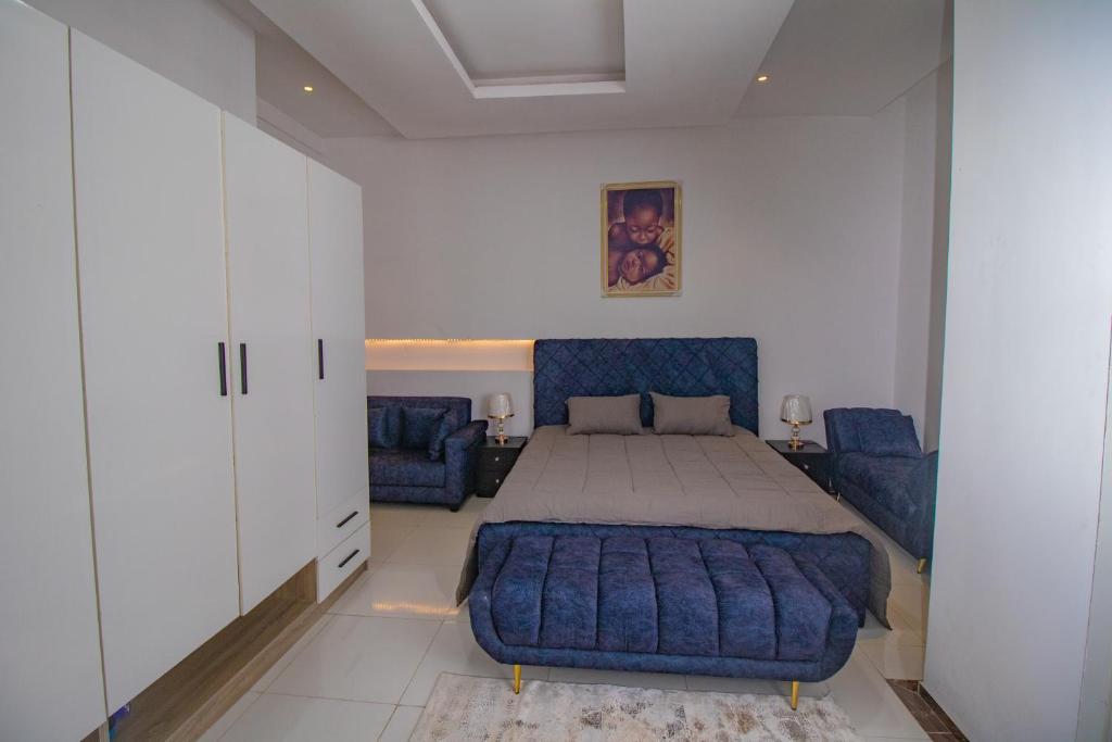 a bedroom with a bed and a blue couch at Chic sanctuary & tranquil oasis in Lekki