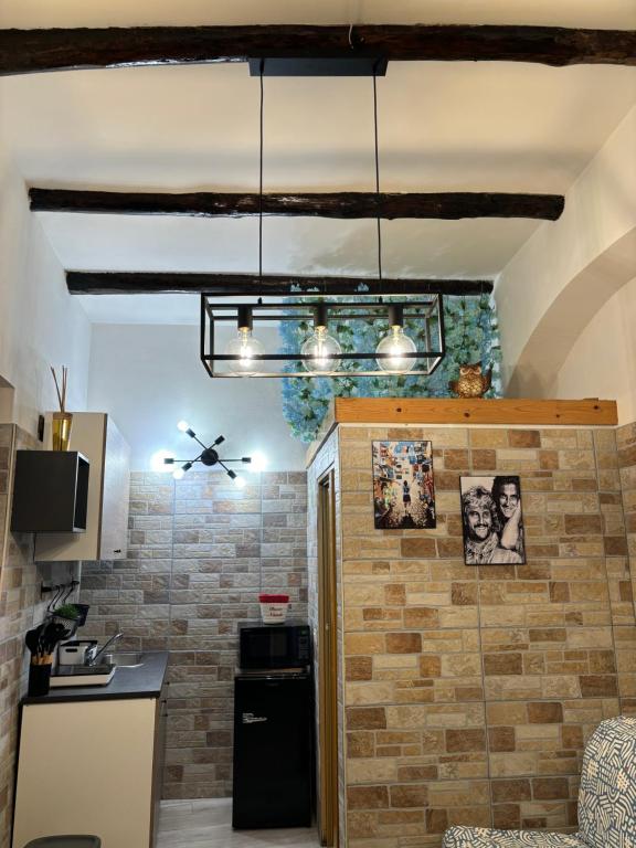 ナポリにあるDimora San Gennaroのレンガの壁のキッチン(黒い冷蔵庫付)