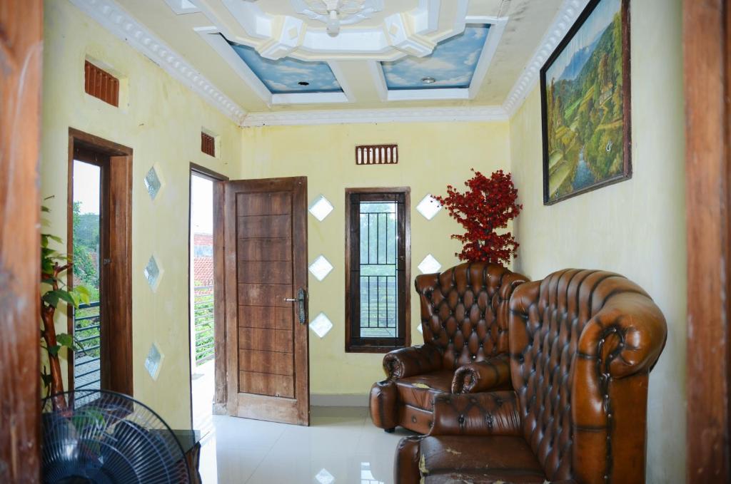 ein Wohnzimmer mit einem Ledersofa und einer Tür in der Unterkunft V & E Home Stay Cimaja Beach in Cimaja