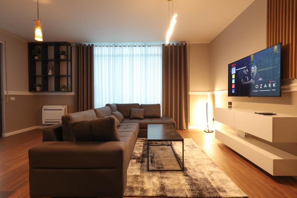 a living room with a couch and a flat screen tv at Grandstay Apartments in Durrës