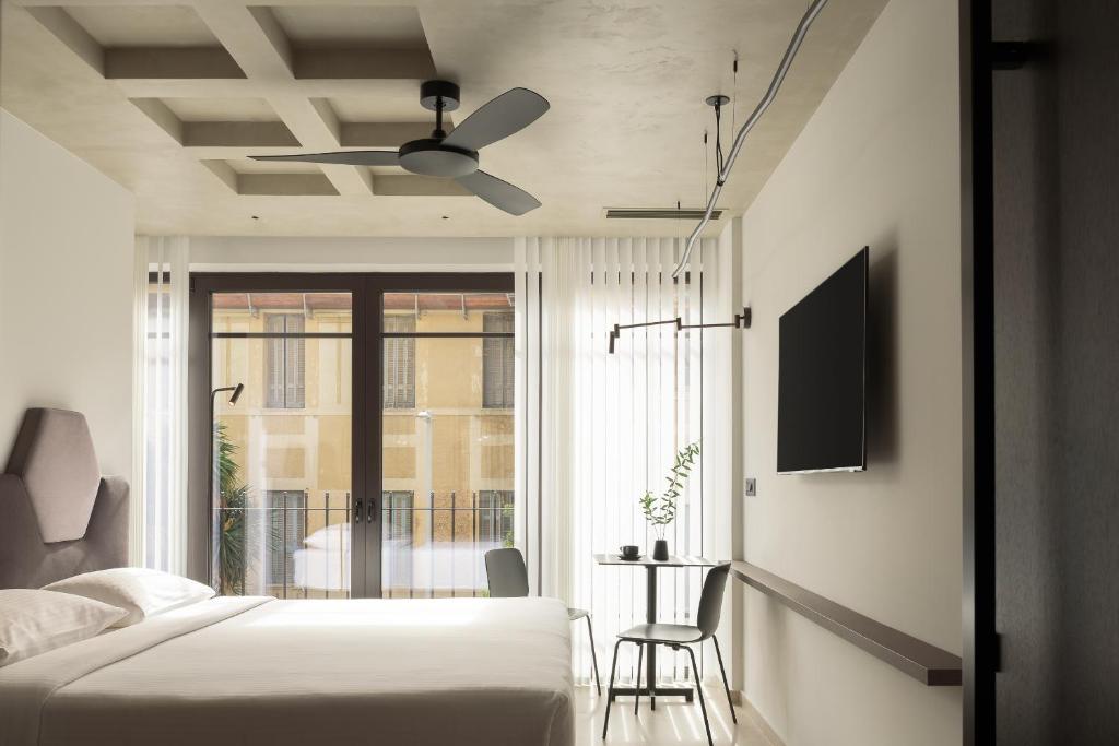 een slaapkamer met een bed en een plafondventilator bij Pleiades Urban Stay by Semavi in Heraklion