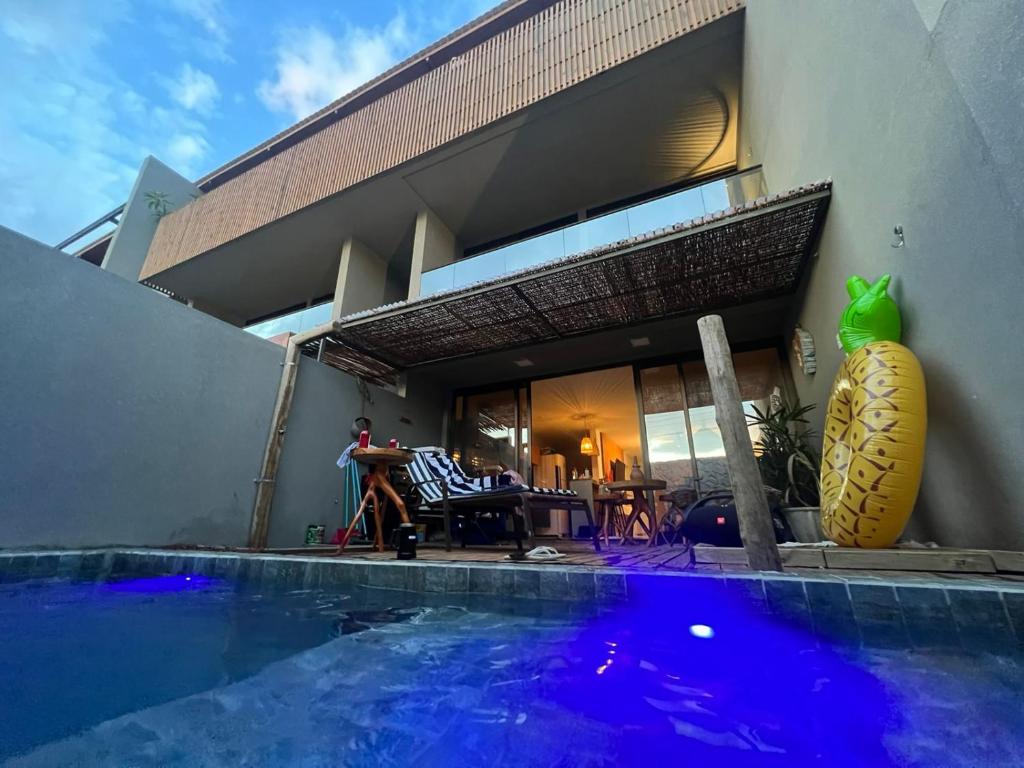una casa con piscina frente a una casa en Kanui Casa Maré 109 en São Miguel dos Milagres