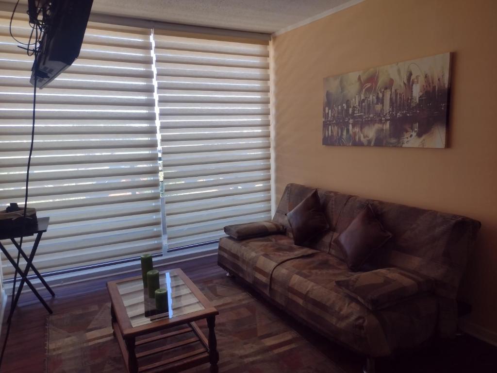 una sala de estar con un sofá y una mesa en Cómodo Departamento, en Los Ángeles
