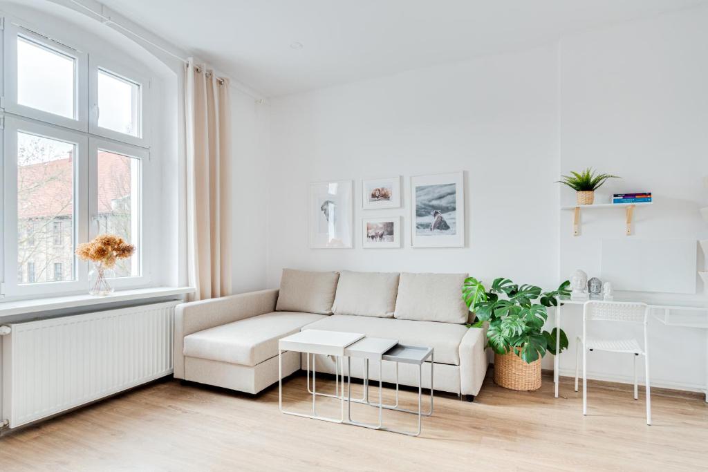 a white living room with a couch and a table at Hann Haven Apartments Ozimska 55 in Opole