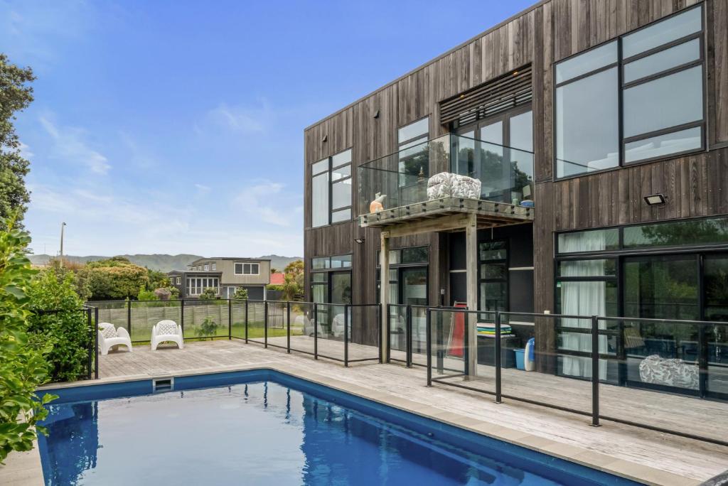 an exterior view of a house with a swimming pool at Sun and Serenity - Waikanae Beach Holiday Home in Waikanae