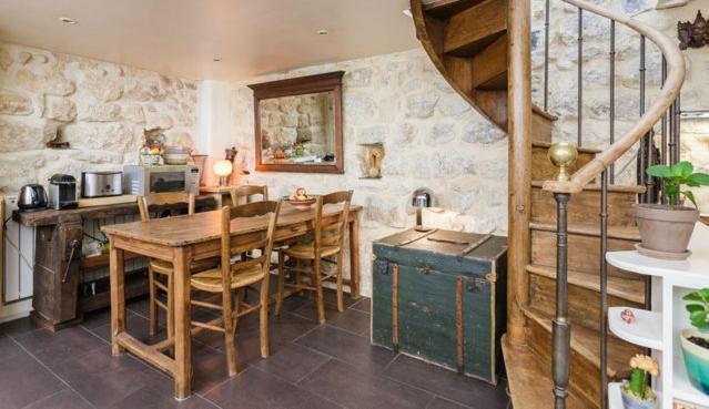 une cuisine avec une table en bois et une salle à manger dans l'établissement Peace and greenery, heart of Paris, à Paris