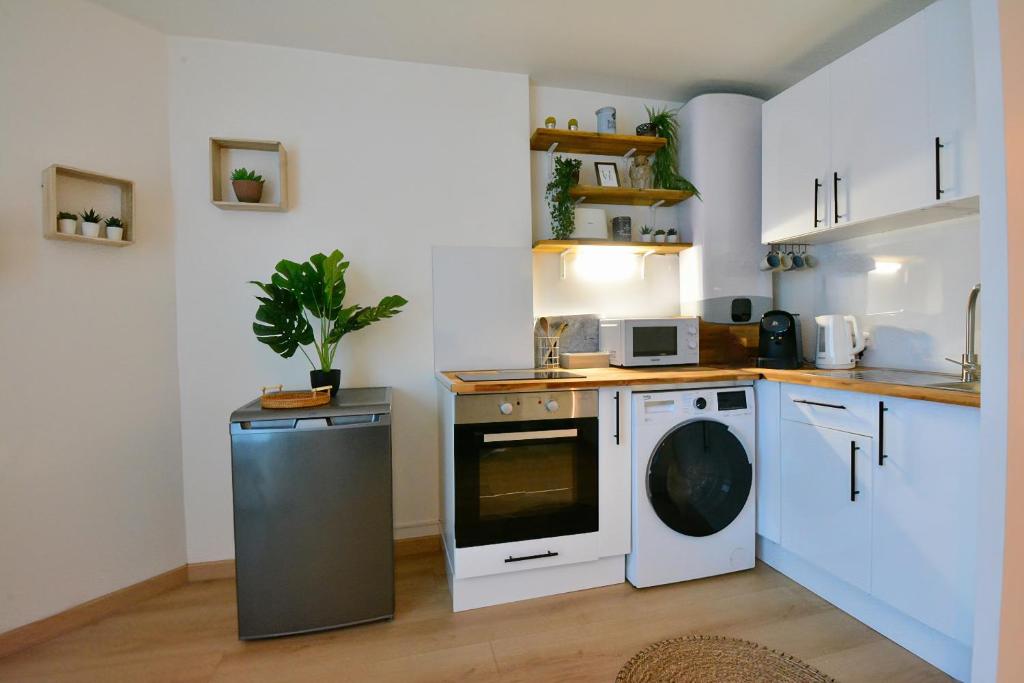 a kitchen with a washing machine and a washer at Take your time in Cluses