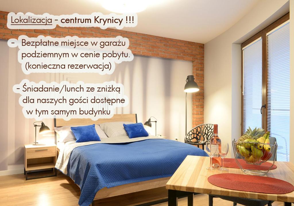 a bedroom with a blue bed and a brick wall at Apartamenty Gaja in Krynica Zdrój