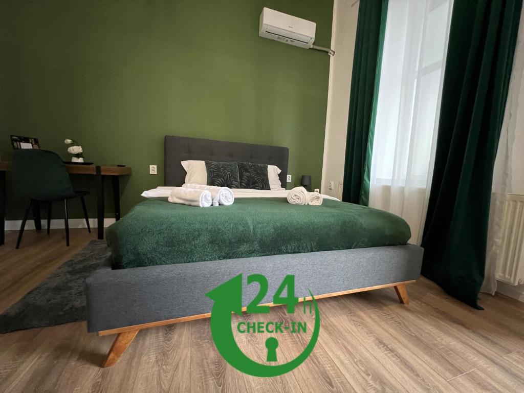 a green bedroom with a bed with a sign on it at Homeland Center Cluj in Cluj-Napoca