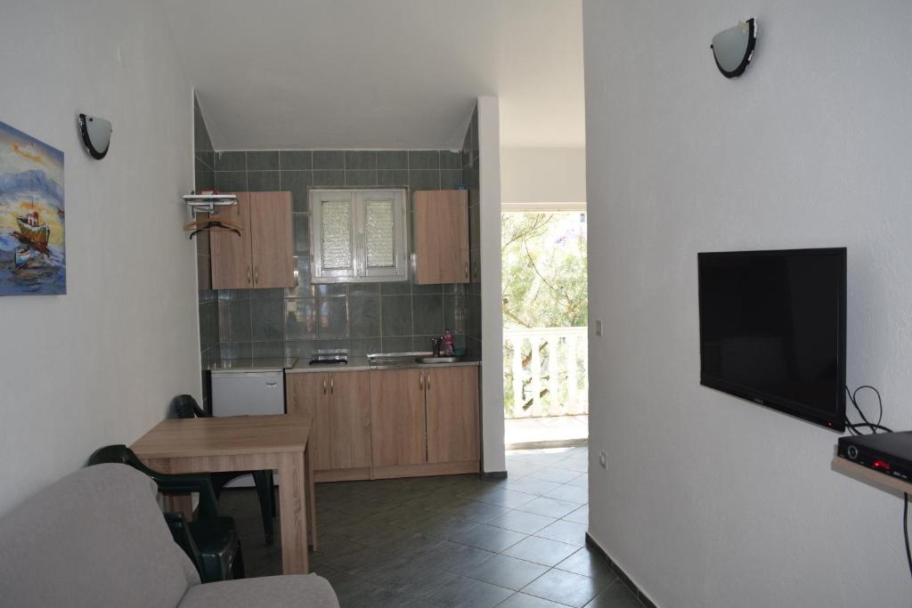 een keuken met een tafel en een tv aan de muur bij Apartment Vidakovic in Budva