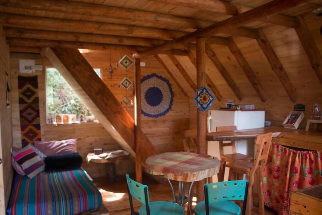 ein Zimmer mit einem Tisch und Stühlen in einer Hütte in der Unterkunft Hermosa cabaña con huerta - Casa verde in Medellín