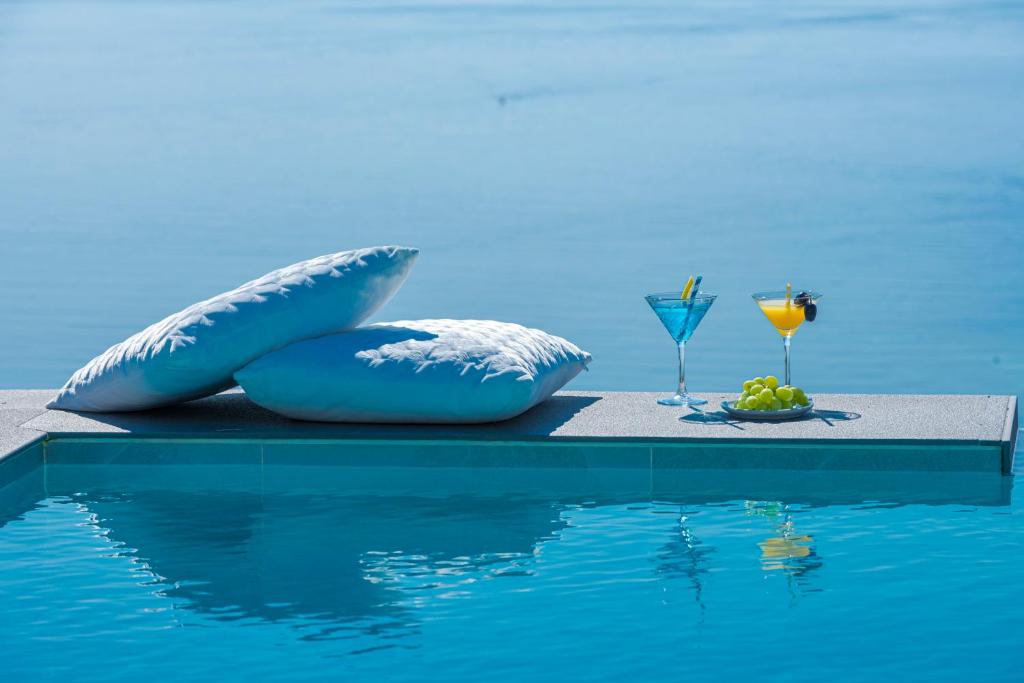 - une piscine avec deux oreillers et une boisson au bord de l'eau dans l'établissement Apartments Villa Poco Loco, à Mlini