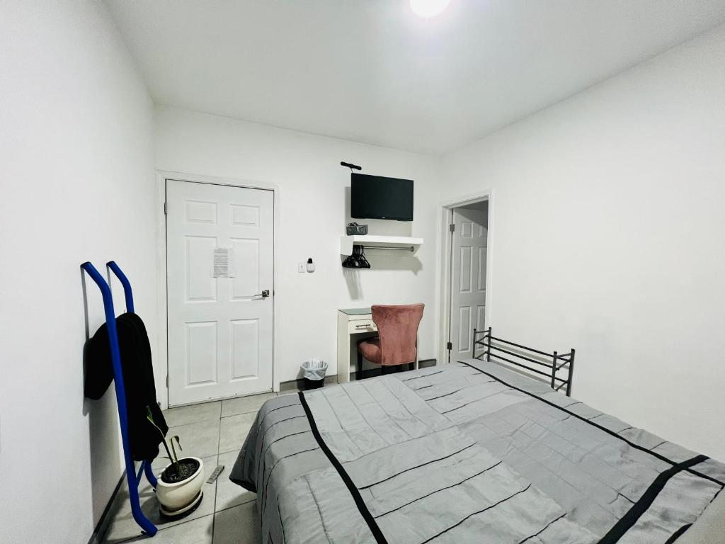 Habitación blanca con cama y escritorio en Casa Ambar, en Tijuana