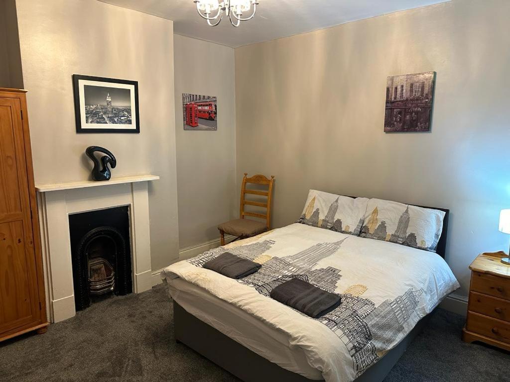 a bedroom with a bed and a fireplace at Luton Town House Near AIRPORT in Luton