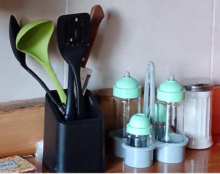 a black container filled with kitchen utensils on a counter at Anacrusa Hostel in Epuyén