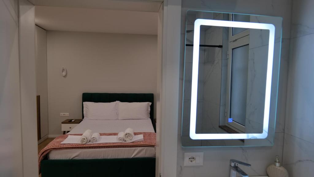 Schlafzimmer mit einem Bett und einem Spiegel an der Wand in der Unterkunft Kristi Apartments 01 in Tirana
