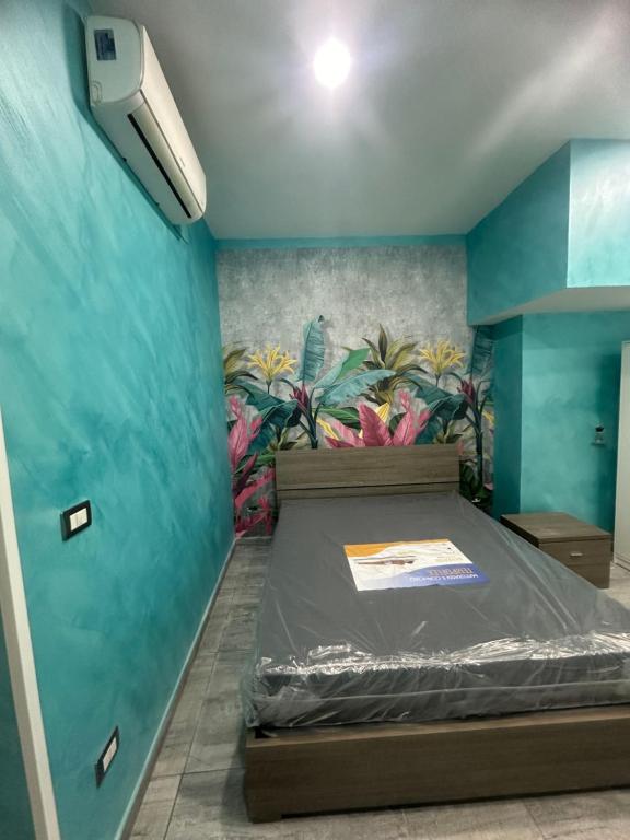 een kamer met een bed met een muurschildering aan de muur bij C.D.M in Napels
