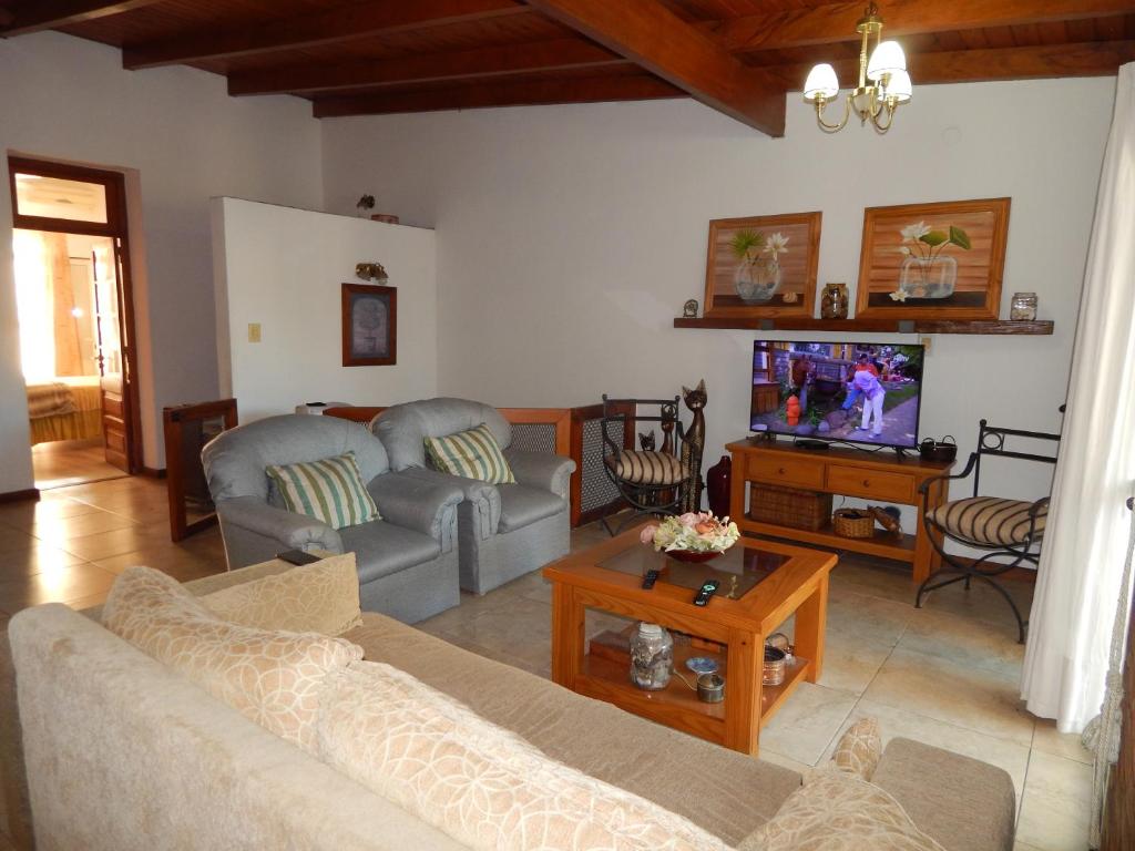 un salon avec un canapé et une télévision dans l'établissement De la plaza, à Concordia