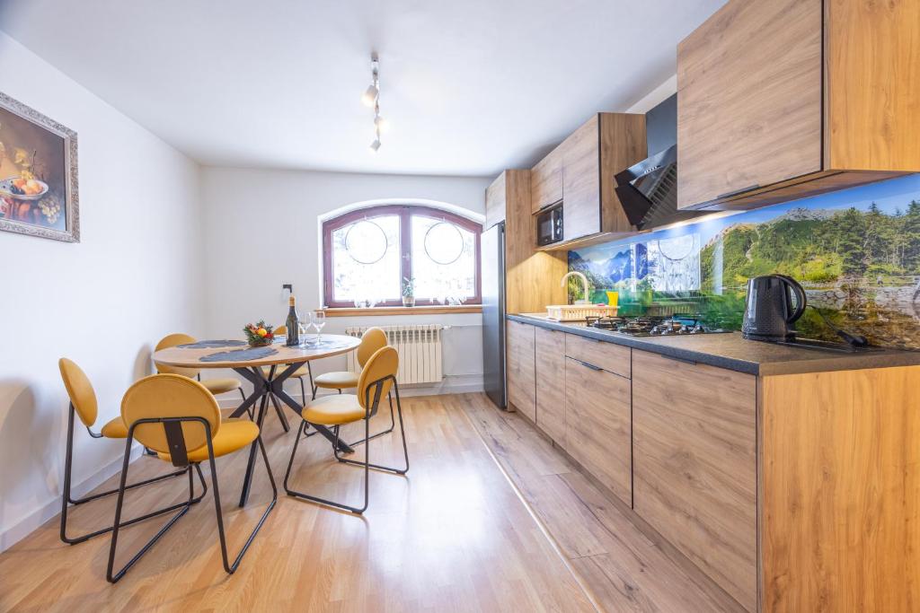 a kitchen with a table and chairs in a room at U Majerczyka Dolina Apartment in Zakopane