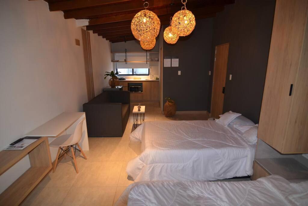 a bedroom with two beds and a table and lights at Amplio y cómodo loft en Medellin. Gran ubicación in Medellín