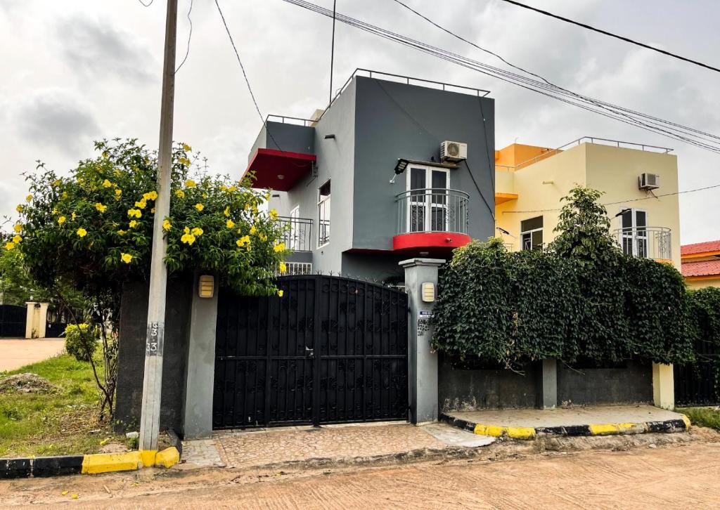 a house with a black fence in front of it at Lav's Place in Brufut