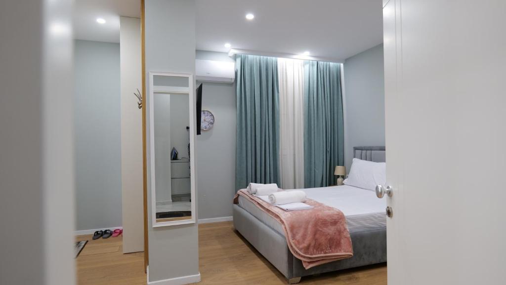 um quarto com uma cama e um espelho em Kristi Apartments 02 em Tirana