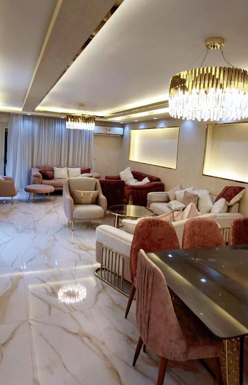 a large living room with couches and a chandelier at شقق فندقيه مفروشه الترا مودرن للايجار in Cairo