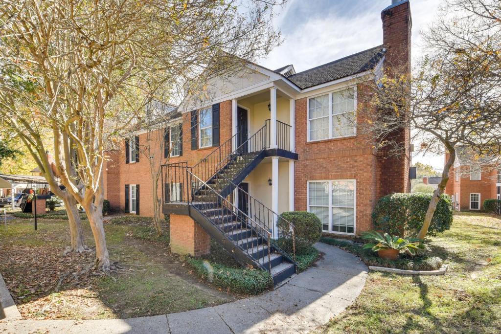 a brick house with a staircase in front of it at Baton Rouge Condo with Balcony, Fireplace and Pool! in Baton Rouge