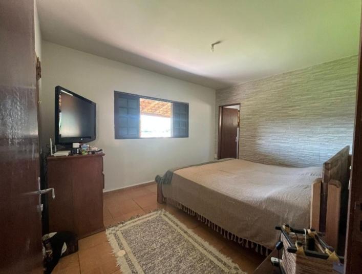 Refúgio da Mantiqueira في باسا كواترو: غرفة نوم بسرير وتلفزيون بشاشة مسطحة