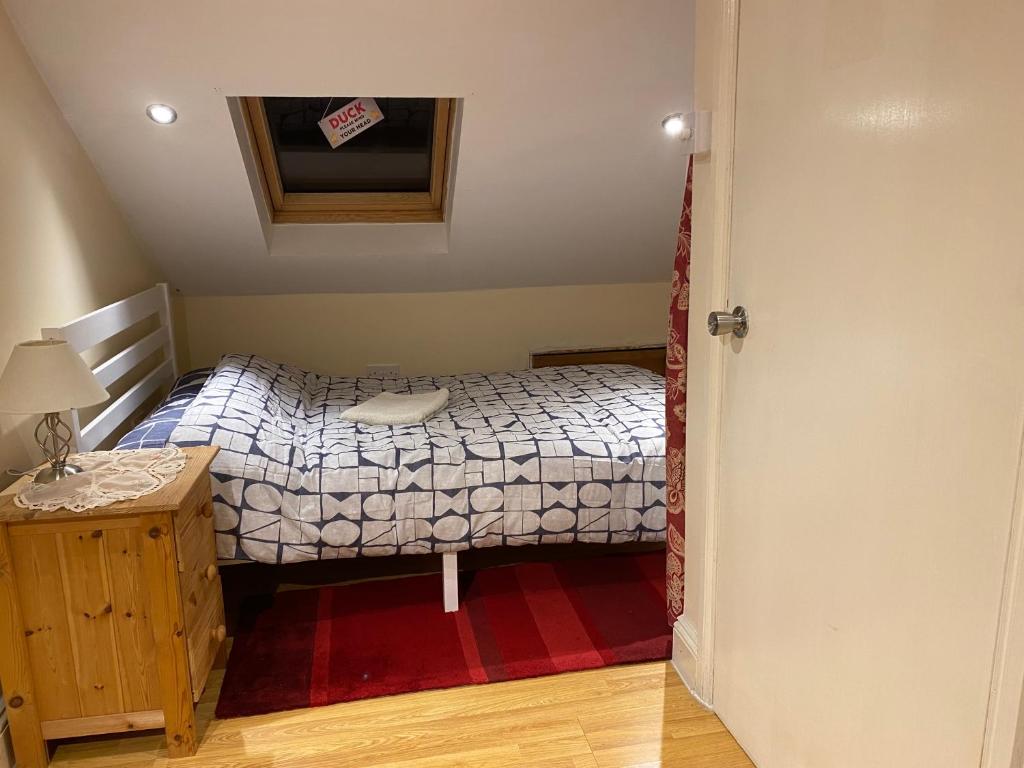 ein kleines Schlafzimmer mit einem Bett und einem Tisch in der Unterkunft River Walk Canterbury in Kent