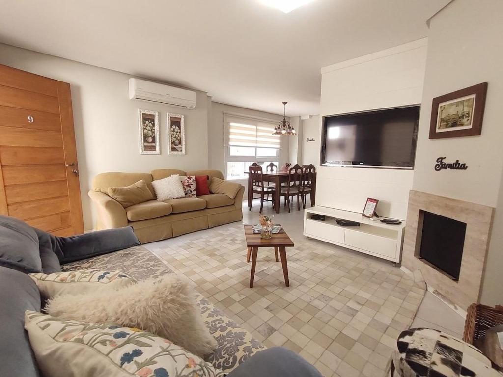 a living room with a couch and a tv at Casa Residencial Samira. Junto ao Centro. in Canela