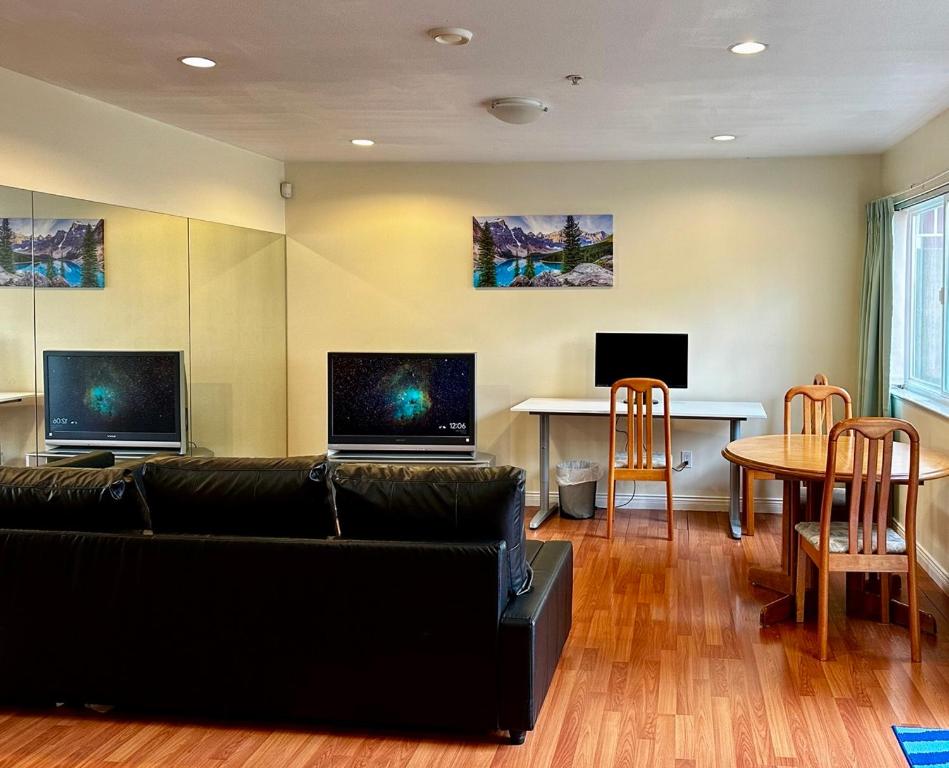 sala de estar con sofá y mesa con sillas en SixPine Suite, en Vancouver