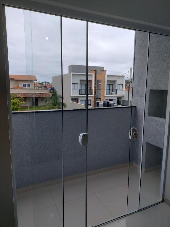 舊巴拉的住宿－Apartamento Novo 500m da praia de Itajuba，开放式玻璃门,享有阳台的景色