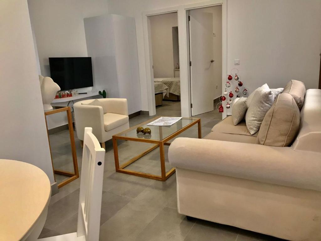 uma sala de estar com um sofá branco e uma mesa em The blue house las Canteras em Las Palmas de Gran Canárias