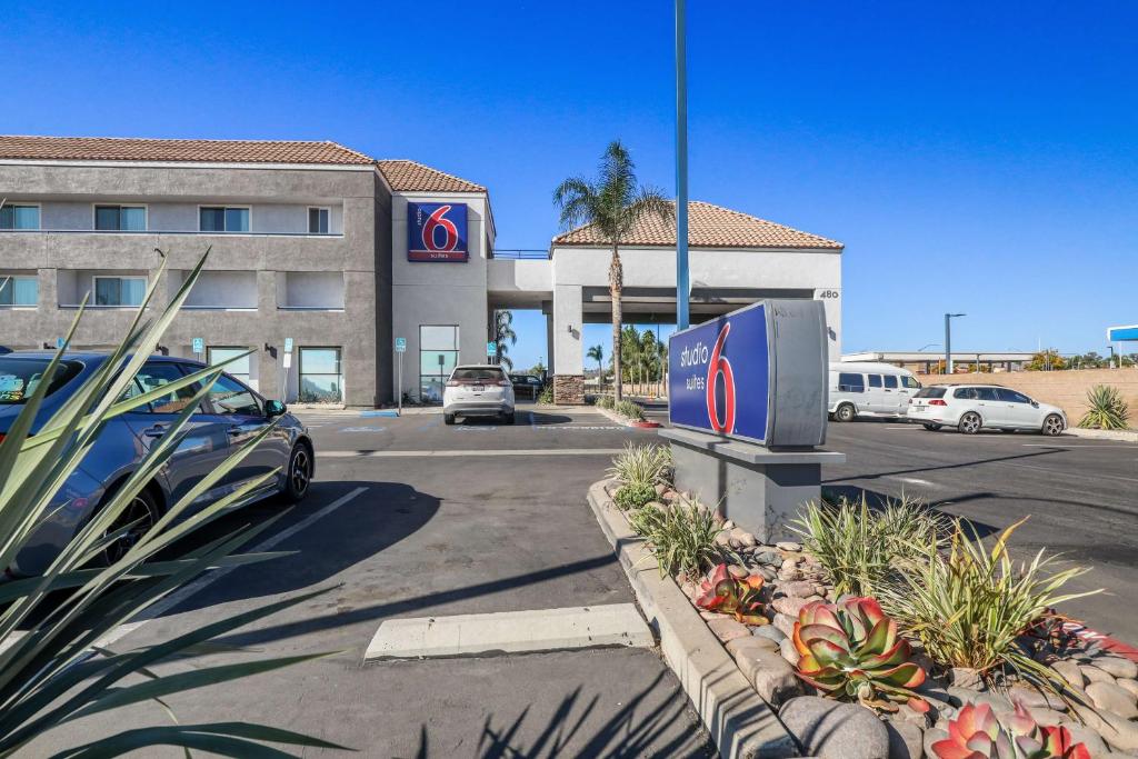 un coche aparcado en un aparcamiento frente a un hotel en Studio 6 Suites Perris, CA, en Perris
