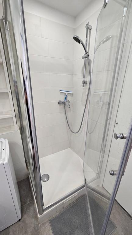 une salle de bain avec une douche avec une porte vitrée dans l'établissement Quatro Venusia, à Sète