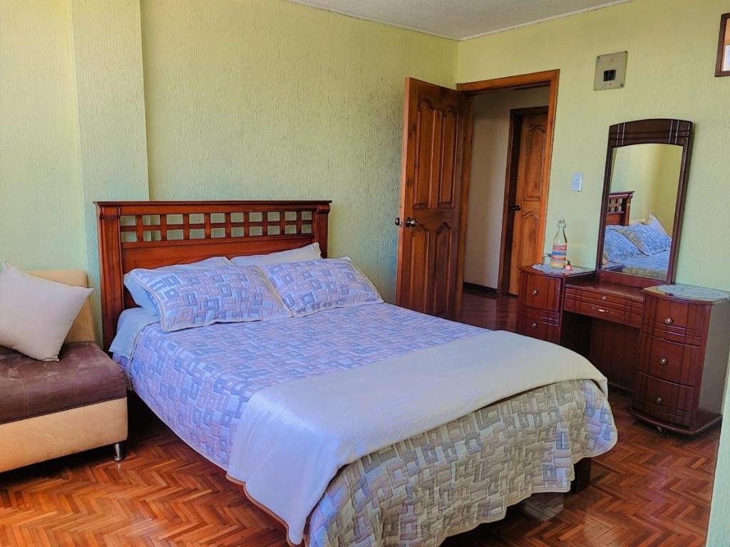 a bedroom with a large bed and a mirror at Casa Cuscungo Family Experience in Quito