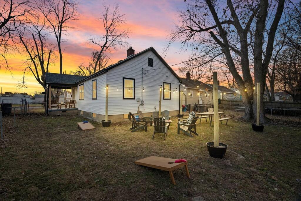 a white house with a picnic table and a sunset at Urban Oasis centrally located near downtown! in Evansville
