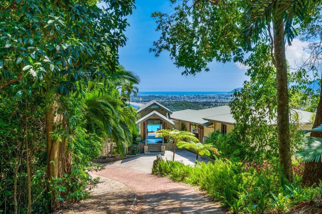 Barong Luxury Home overlooking Cairns Unrivalled privacy and location في كيرنز: عقارات بها ممر يؤدي إلى منزل به أشجار